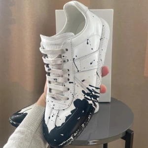 Maison margiela paint splatter - Säljer nu dessa extremt feta maison margiels med paint splatter i storlek 43/44 , de är endast använt ett fåtal gånger och är otroligt bra skick, inga som helst undersida skador osv. Box medföljer. Kommer självklart rengöra de djupare inför försäljning. Hör av dig vid frågor!