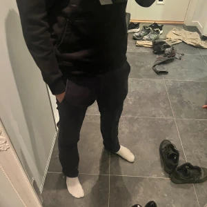 Mörkblå chinos från Selected Homme - Svarta byxor från Selected Homme med klassisk rak passform och normal midja. Snyggt stilrena och passar perfekt till en chill och avslappnad look. Materialet är mjukt och bekvämt, troligtvis bomull eller en bomullsblandning. Diskret design utan synliga detaljer.