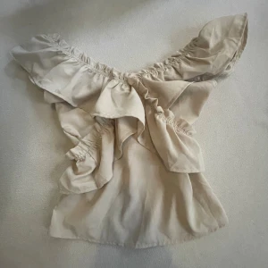 Beige offshoulder blus med volang - Säljer min supersnygga beigea ofshoulder volang-blus, den är även proffesionellt omsydd i midjan. Köp nu jag postar snabbt!!