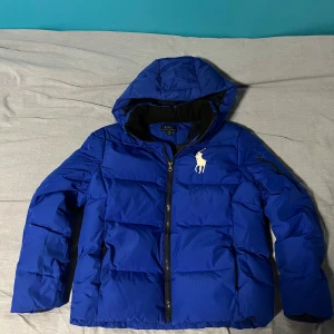 Ralph lauren pufferjacka - Snygg jacka från ralph Lauren. Äkta produkt. Storlek i taggen är 14-16 years men den sitter som en xs. Nypris runt 3000kr. Det finns en fläck på magen därav priset. Fläcken går dock att få bort enkelt. Mått: längd: 58cm axelbredd: 45cm. Fraktar samma dag!