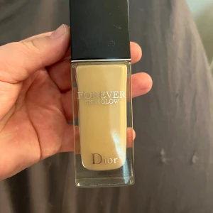 Dior Forever Skin Glow Foundation 1.5W - Dior Forever Skin Glow Foundation i nyansen 1.5W. Flytande foundation med SPF 20, ger strålande finish och återfuktar huden. Kommer i en lyxig glasflaska med svart lock och silverfärgad Dior-logga. Perfekt för dig som vill ha en naturlig glow och jämn hudton. Är ca halva kvar om inte minns fel, är helt fel färg för mig