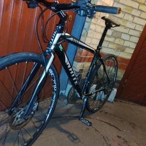 White SC Lite FF 854 - Snygg och lätt hybridcykel White SC Lite FF 854 i svart med gröna detaljer. Utrustad med skivbromsar och sportiga däck, perfekt för pendling och träning. Cykeln ser ut att vara i gott skick med mindre spår av användning, inga synliga större defekter.