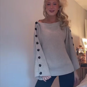 Beige Stickad Tröja med Knappar - Hej! Säljer denna såå söta beiga finstickade tröjan från Gina Tricot med svarta stora knappar på sidan av ärmarna då den inte kommer till användning. Tröjan är i mycket fint då den endast använts 2-3 gånger. Verkligen helt perfekt nu till hösten!🍁Den köptes på Gina Tricot för ca två år sedan och finns därav inte kvar i deras sortiment och är väldigt eftertraktad! Om du skulle ha några funderingar är det bara att höra av dig, annars går det superbra att trycka på ”köp”.