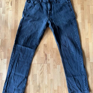 Svarta raka jeansbyxor från jack and jones - Säljer ett par svarta jeansbyxor i klassisk rak modell. Jeansen har fem fickor, bälteshällor och är tillverkade i ett slitstarkt denimtyg. Perfekta för dig som gillar en enkel och tidlös look.