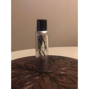 Color Wow Extra Mist-ical Shine Spray - Säljer en silvrig sprayflaska med svart lock från Color Wow, Extra Mist-ical Shine Spray. Flaskan rymmer 162 ml och ger glans till håret. Modern design med tydlig logga och text i svart. Perfekt för dig som vill ha extra shine och en fräsch look.
