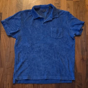  Berkeley Blå frottéskjorta - size XL - Blå kortärmad skjorta från Berkeley i mjuk frotté. Skjortan har klassisk krage, bröstficka med broderad logga och relaxed fit. Perfekt för chill dagar när du vill ha något bekvämt men ändå snyggt.