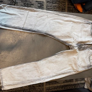 Haikure California 195 jeans, grå 34 - Snygga grå jeans från Haikure, modell California 195, med old black denim tvätt. De har klassisk femficksdesign, raka ben och subtila slitningar vid fickor och sömmar. Tillverkade i Italien med en cool, ljusgrå ton och mörkare detaljer vid fickorna.