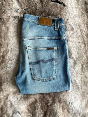 Nudie jeans  - Säljer ett par ljusblå jeans från Nudie med slitningar på knäna i modellen Tape Ted storlek 32/32. De är i bra skick, pris kan diskuteras. Skriv om ni undrar över något!