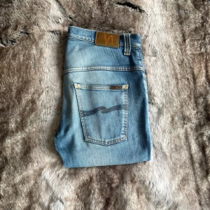 Nudie jeans  - Tja, säljer dessa nudie jeans i modellen Tape Ted. Storlek 32/32. Bra skick med lagade slitningar. 105 cm långa