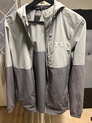 Under amour vindjacka  - Säljer denna snygga under amour vindjackan. Passar till allt och speciellt till väder där de inte behövs mycket plagg på sig och vill styla upp outfiten lite extra. 