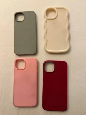 Fyra mobilskal i olika färger - Säljer fyra snygga mobilskal till iPhone i olika färger: grå, beige med vågig kant, ljusrosa och vinröd. Det vinröda skalet är från Holdit. Alla skal är i mjukt silikonmaterial och har en stilren design som skyddar mobilen. Köp alla för endast 200 kr!!! alltså 50 kr per skal! passar till iphone 13 och 13 pro. 
