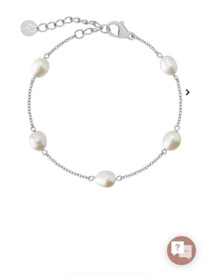 Edblad armband med vita pärlor - Stilrent armband i silverfärgad metall med fem vita pärlor jämnt fördelade längs en tunn kedja. Armbandet har justerbar längd och ett klassiskt karbinlås. Perfekt för dig som gillar en enkel men elegant look.