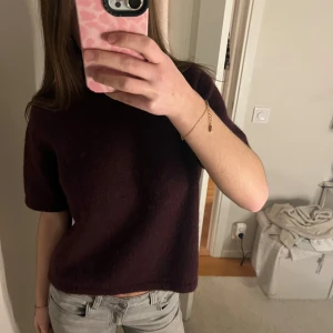 Vinröd stickad topp med kort ärm - En vinröd/burgundy stickad topp med korta ärmar och rak passform. Mjuk och skön utan några defekter. Storleken är 158/164 men passar mig som är 166 och vanligtvis bär xs.