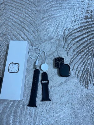 Apple Watch Series 9 45mm svart - Apple Watch Series 9 med 45mm boett i svart aluminium. Medföljer svart silikonarmband, magnetisk laddare och originalförpackning. Klockan har en modern, fyrkantig design och en stor, tydlig skärm. Perfekt för dig som vill ha koll på både träning och notiser direkt på handleden.