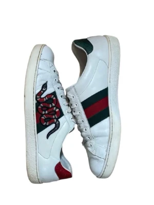 Gucci Ace vita sneakers - Klassiska och eftertraktade designerskor med gröna/röda ränder och broderad orm på sidan. Väldigt populär modell som passar till allt. Nypris ca 6000 kr säljs för 1949 kr