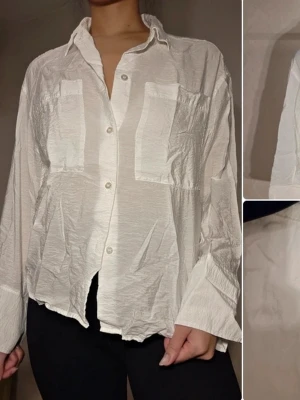 Vit skjorta från STOCKH LM Studio - Säljer en vit skjorta från STOCKH LM Studio i storlek XS. Skjortan har lång ärm, två stora bröstfickor och knappar framtill. Materialet är lätt och har en skrynklig struktur för en avslappnad look. Perfekt till jeans eller kjol.