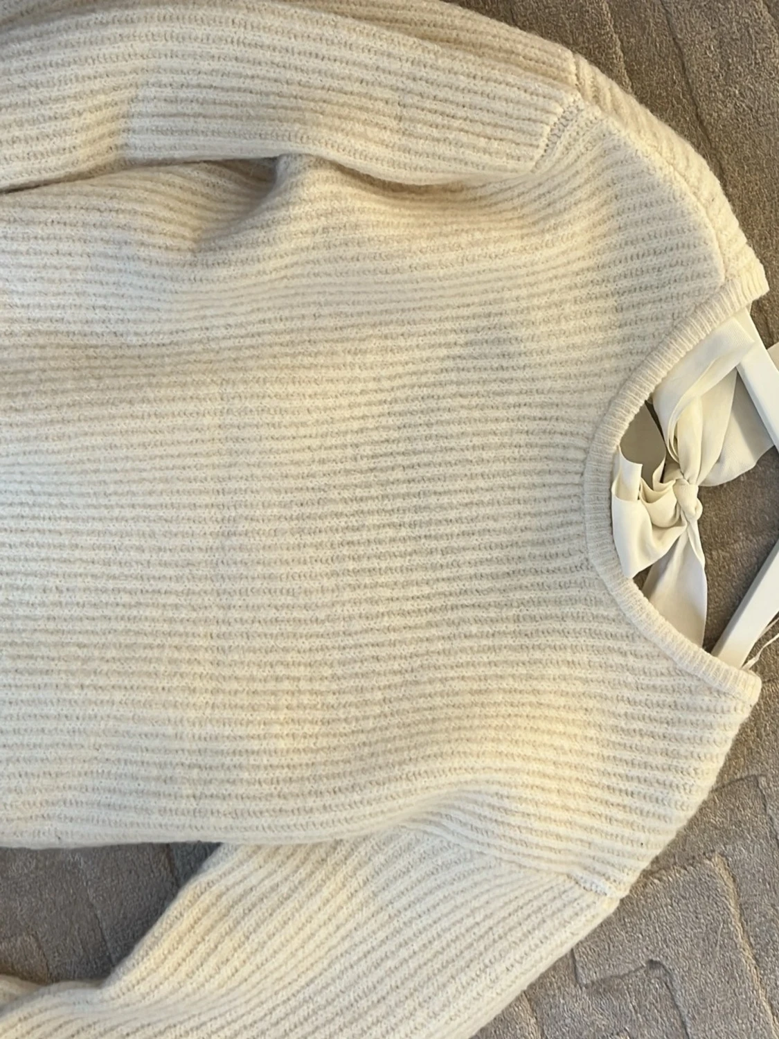 Krämvit stickad tröja med rosett