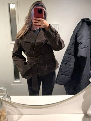Mörkbrun trenchcoat med bälte - Snygg mörkbrun trenchcoat från NA-KD. Knappt använt den!! Köpte den för 2 månader sedan😍nypris på den är 1200 men säljer den för 850