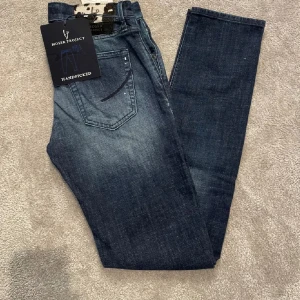 Handpicked jeans - Snygga mörkblå jeans från hand picked med klassisk femficksdesign och coolt patch i svartvitt vid linningen. Jeansen har en rak passform och är tillverkade i mjukt denimtyg som sitter skönt hela dagen.