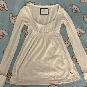 Vintage 2000s Abercrombie tröja  - Säljer denna supersöta Abercrombie tröjan som är väldigt svår att få tag i, perfekt till hösten och vintern, den är långärmad, Blusen har ett diskret hålmönster i tyget och vid armen, detaljer under bysten och älg märket finns. Tillverkad i mjuk bomull. Kommer ej gå ner i priset på ett tag. Storlek S men skulle säga att den passar bättre XS-XSS 