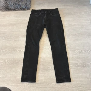 Svarta jeansbyxor med smal passform - Snygga svarta jeansbyxor från volt med klassisk femficksdesign och smal passform. Byxorna har en stilren look med svarta sömmar och ett diskret svart läderpatch bak i midjan. Perfekta för dig som gillar en enkel och clean stil.