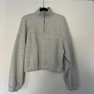 Grå kofta med quarter-zip - Mysig kofta från weekday. Något croppad i modellen. Fleece inuti. Endast använd fåtal gånger. Inga anmärkningar.