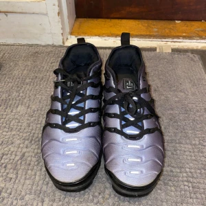 Nike Air Vapormax Plus Svart/Silver - Nike Air Vapormax Plus sneakers i svart och silver med futuristisk design och synlig Air-sula. Ovandel i syntetmaterial med svarta detaljer och snörning. Swoosh-logga på sidan och 'Vm Air' på hälen. Grym komfort och unik look för dig som vill sticka ut. Bubblan på vänstra foten är sprucken men man märker inte det när man går, utan kartong och går ner i pris vid snabb affär 
