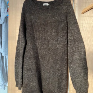 Brun stickad tröja från Filippa K - Mysig brun stickad tröja från Filippa K i storlek XS. Tröjan har en klassisk rund halsringning och långa ärmar. Den är ribbstickad och har en loose passform, perfekt för kyliga dagar.