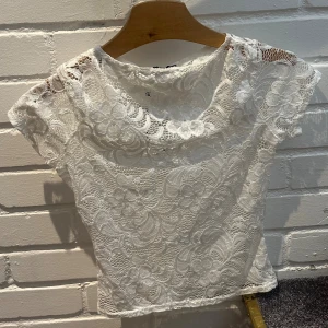 Vit spetstopp  - Supersöt vit topp från Boohoo i stl 34. Hela toppen är täckt av blommig spets med korta ärmar och rund halsringning. Passar både till fest o vardag🤍prislapp finns kvar