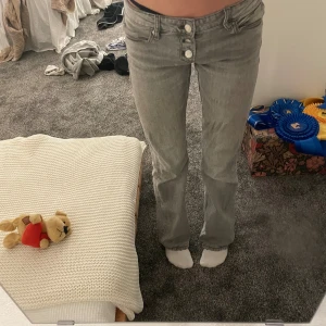 Grå low waist jeans med bootcut - Säljer ett par grå jeans som är low waist. Dem är från Gina Tricot dem är i bra skick men har ett jätte litet hål inne på låret men knget man tänker på. Ny pris 245