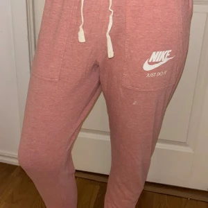 Rosa mjukisbyxor från Nike strl M - Rosa mjukisbyxor från Nike. Sköna och perfekta för chill eller träning. Tillverkade i mjukt bomullsmaterial.