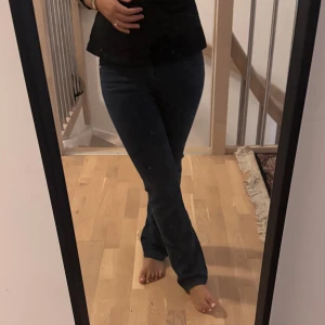 Mörkblå raka jeans - Säljer ett par mörkblå jeans med klassisk femficksdesign och raka ben. Jeansen har normal passform och midja, och är tillverkade i ett mjukt denimtyg som sitter snyggt på kroppen. Perfekta för dig som gillar en tidlös och enkel stil.