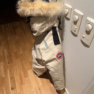 Beige/Vit  Canada Goose Heli Arctic - Säljer en beige/vit exklusiv jacka från Canada Goose med stor huva och äkta pälsdetalj. Jackan har flera fickor, reflexdetaljer och klassisk logga på ärmen i den mycket sällsynta modellen Heli Artic, nypris ~21.000kr, cirka pris på begagnat marknaden ~ 10-11.000kr, säljes nu för endast 6000kr. Storlek M. Passar även L. Perfekt för kalla vinterdagar och riktigt snygg streetstil. Jackan är använd max 10 gånger pga av att jag har 4 olika canada goose jackor. 
