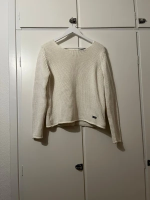 Krämvit virkad kofta med träknappar - Krämvit virkad tröja i stl S, med knappar i ryggen. Från Holebrook Sweden från början. Passar perfekt att ha över ett linne/ klänning, eller på egen hand. Den är ganska använd, utan tydliga tecken, utöver lite slitna knappar.