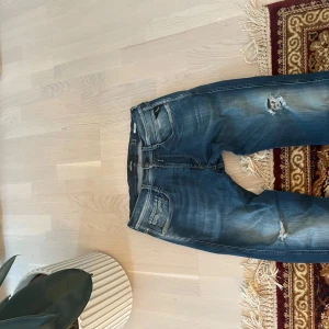 Blå jeans från Replay - Säljer ett par snygga blå jeans från Replay i modellen Anbass. De har en cool distressed look med slitningar på knäna och en bekväm passform. Perfekta för en casual stil och funkar året runt. 🕶️ bra skick, storlek 33:32 pris kan diskuteras