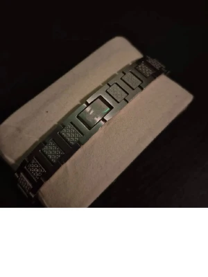 Stilrent armband i rostfritt stål - Snyggt armband i silverfärgat rostfritt stål med rektangulära länkar och graverade detaljer. Armbandet har en modern och stilren design med mönstrade partier som ger en cool touch. Perfekt accessoar för dig som gillar minimalistisk stil.