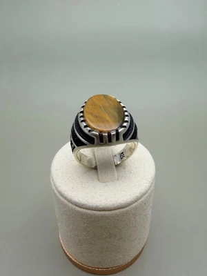Silverring med tigeröga-sten - Snygg silverring med en oval tigeröga-sten i mitten. Ringen har detaljerade svarta inslag längs sidorna som ger en cool kontrast till den varma, bruna stenen. Perfekt accessoar för dig som vill sticka ut med stilrena detaljer. Storlek: ca. 20,2 mm
