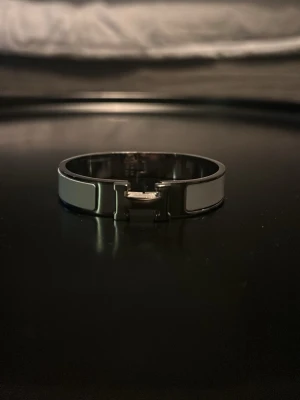 H- armband - Snyggt vit H- armband i metall. Den har en modern design som passar perfekt till din outfit. Metallens silvriga ton matchar den vita emaljen för en lyxig känsla. Kom dm för mer bilder/frågor?!