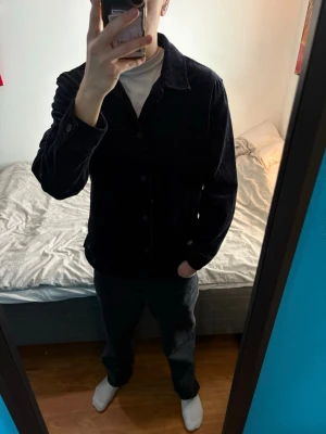 Mörkblå Manchester overshirt från H&M - Stilren mörkblå overshirt i mjuk manchester från H&M. Klassisk krage, knäppning framtill och en bröstficka. Perfekt lager-på-lager-plagg med avslappnad passform och snygg struktur i tyget.