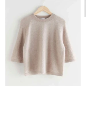 Beige stickad tröja & Other Stories - Mysig beige stickad tröja från & Other Stories. Tröjan har rund halsringning, trekvartsärmar och är gjord i en mjuk ullblandning. Använd fåtal gånger.