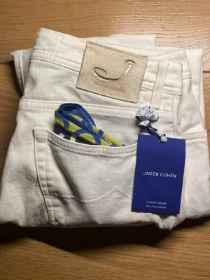 Vita jeans från Jacob Cohën - Snygga vita jeans från Jacob Cohën med klassisk femficksdesign och exklusiv logotyp-patch bak. Jeansen är i mjukt denimtyg och har en modern passform. Perfekta för dig som vill ha en stilren och fräsch look. 