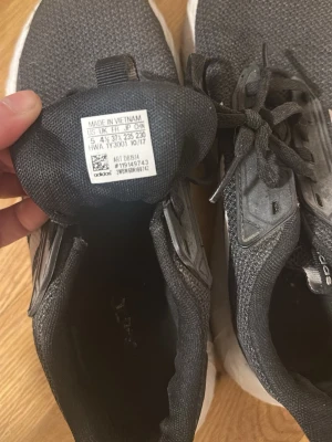 Adidas svarta sneakers med vita ränder - Snygga svarta Adidas sneakers med klassiska vita ränder på sidorna. Fint skick men lite smutsiga undertill. Mjuk o skön sula att gå i 