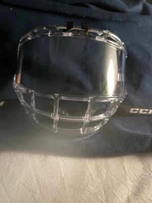Ishockeyvisir som är CCM och storlek jr - Säljer ett ishockeyvisir med integrerat galler från CCM.  Perfekt för dig som spelar hockey och vill ha bra sikt och skydd.