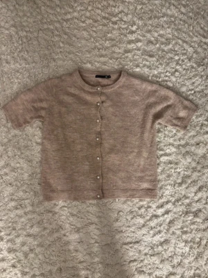 Beige stickad kofta med pärlknappar - Den har tappat en knapp nästan längst ner, vilket inte syns på bilden, därmed det billiga priset 💘