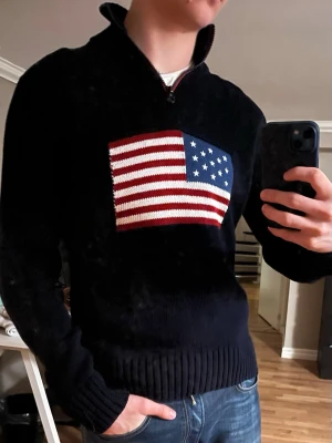 Ralph Lauren Flagg tröja - Säljer en snygg Ralph Lauren flagg/USA halfzip tröja. Jättefint skick, jag skulle säga näst intill nyskick. Hör av dig vid funderingar😊