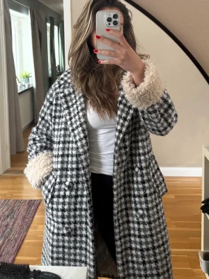 Rutig teddyjacka från Molly Bracken - Pris kan diskuteras vid snabbt köp!! Säljer en svartvit rutig teddyjacka/kappa från Molly Bracken. Jackan har stora fluffiga ärmslut i beige teddy, dubbelknäppning med knappar och två fickor framtill. Perfekt statement-plagg med coolt mönster och mysig känsla. 
