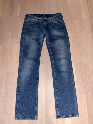 Replay blå jeans straight fit - Snygga blå jeans från Replay med klassisk femficksdesign och raka ben. Jeansen har en normal passform och är tillverkade i slitstarkt denimtyg. Färgen är mellanblå med lätt tvättade detaljer och tydliga sömmar. Perfekta för dig som gillar stilrena och tidlösa jeans. Storlek w27 l30. Passar perfekt för 166-174cm. Skriv privat om ni vill ha rådgivnign ifall byxorna passar er! Tveka inte på att ge prisförslag!  Svarar snabbt! Använda väldigt fåtal gånger!