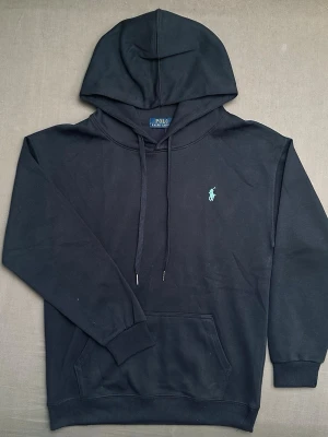 Mörkblå hoodie från polo Ralph lauren  - Snygg mörkblå hoodie från polo Ralph lauren med ljusblått broderad logga på framsidan. Bra skick ändats testad på en gång 