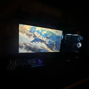 Stationär gamingdator med RGB-belysning - Kraftfull stationär gamingdator med RGB-belysning, vätskekylning och flera fläktar för optimal kylning. Snyggt chassi med glaspanel, komplett med tangentbord och skärm. Datorn ser välskött ut utan synliga defekter eller slitage. Perfekt för gaming och krävande applikationer.