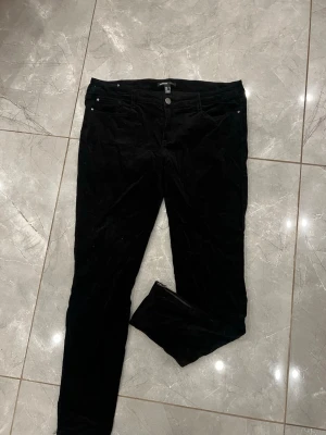 Vintage manchesterbyxor - Vintage svarta manchesterbyxor från mango med tajt passform och dragkedjedetalj vid ankeln. 